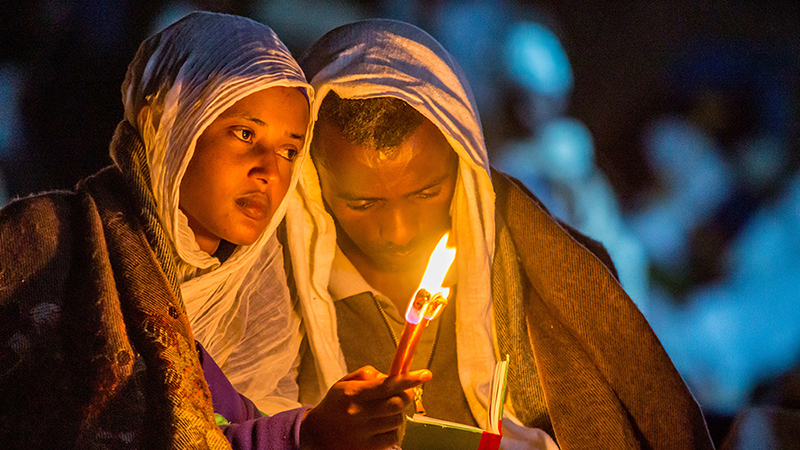 Deux jeunes personnes éclairées par une bougie à Lalibela